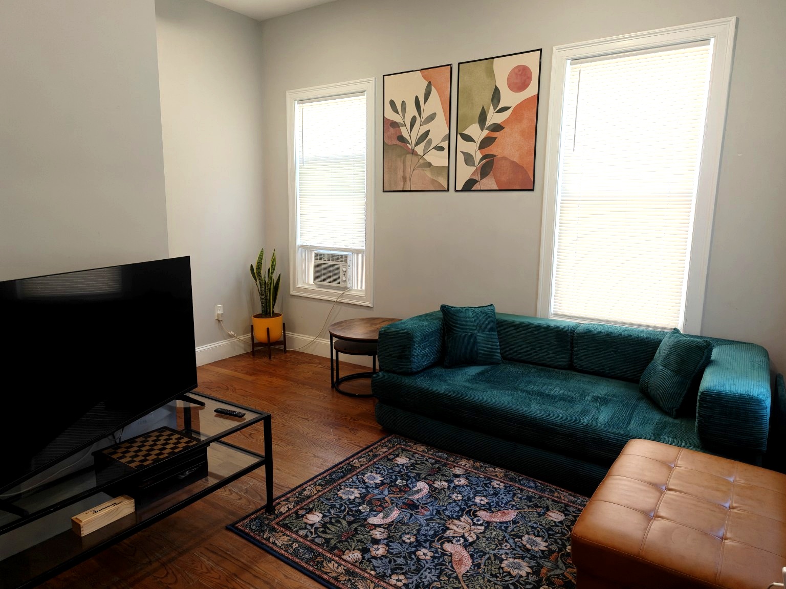 Living room with deep teal sofa and patterned rug